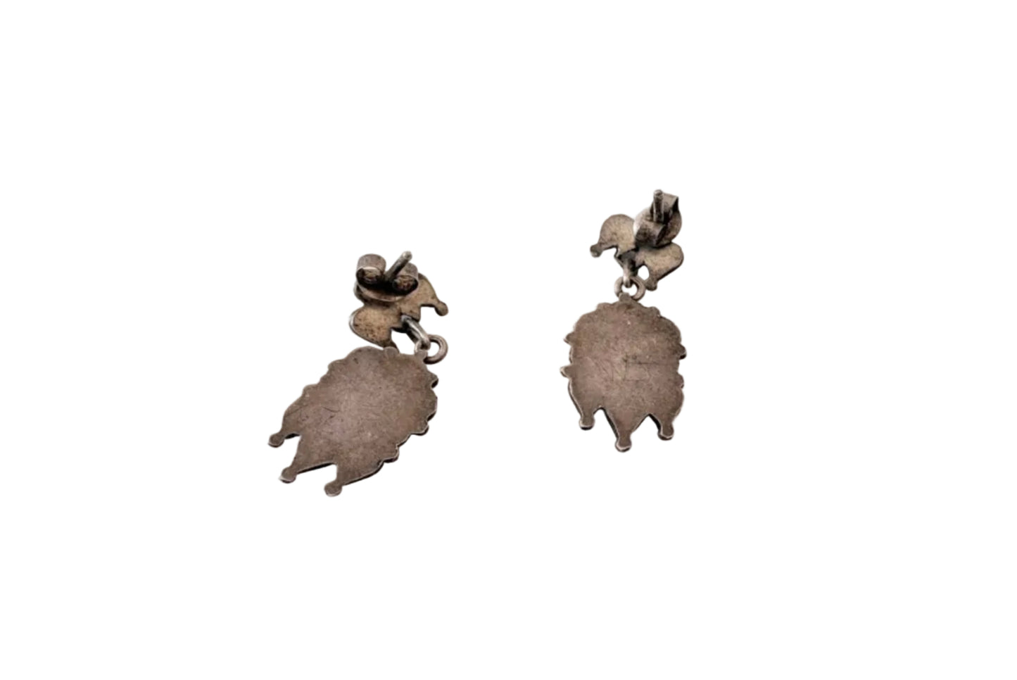 Pair of silver leaf-shaped earrings on a light background