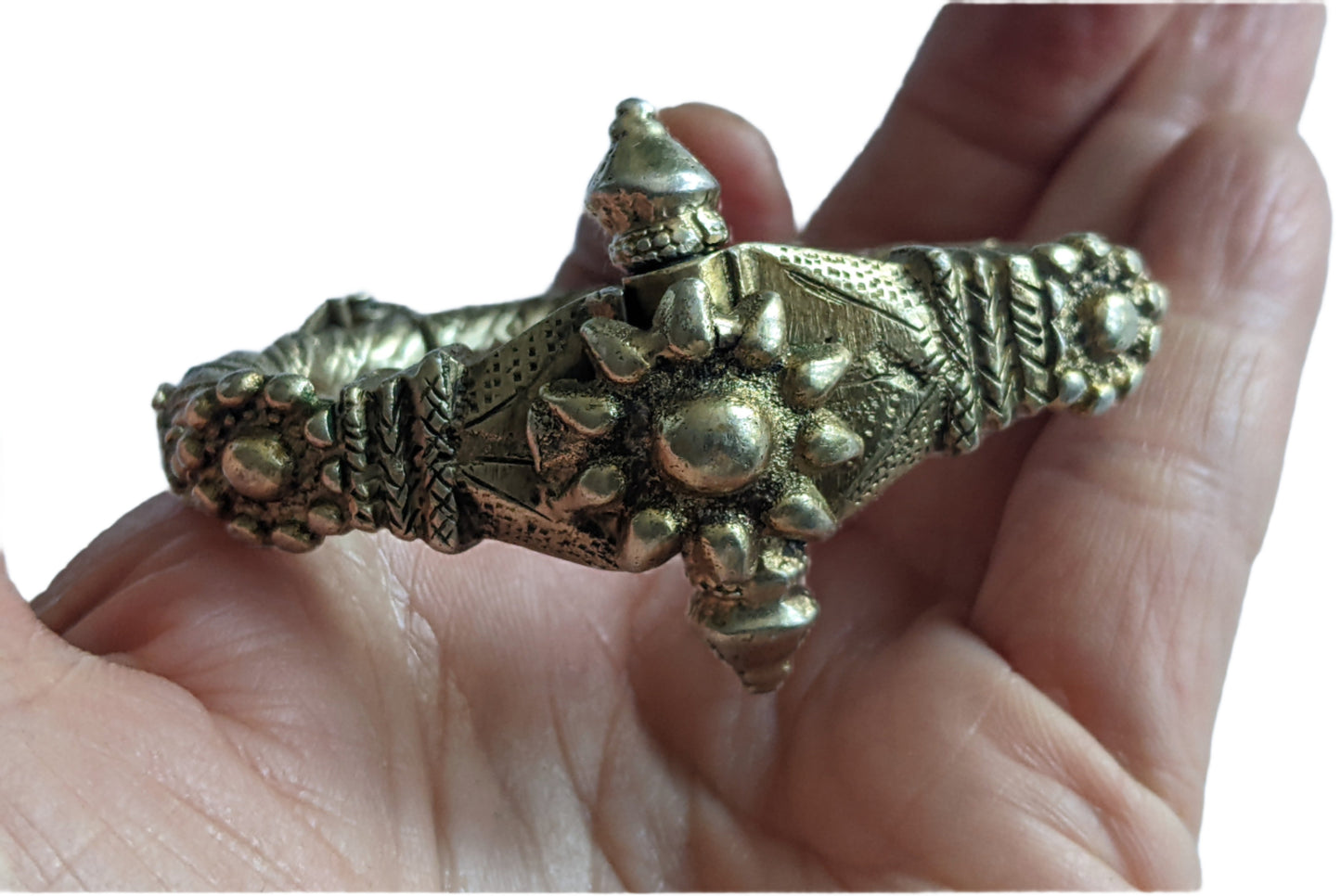 Bracelet with sunburst pattern held in a hand against a light background
