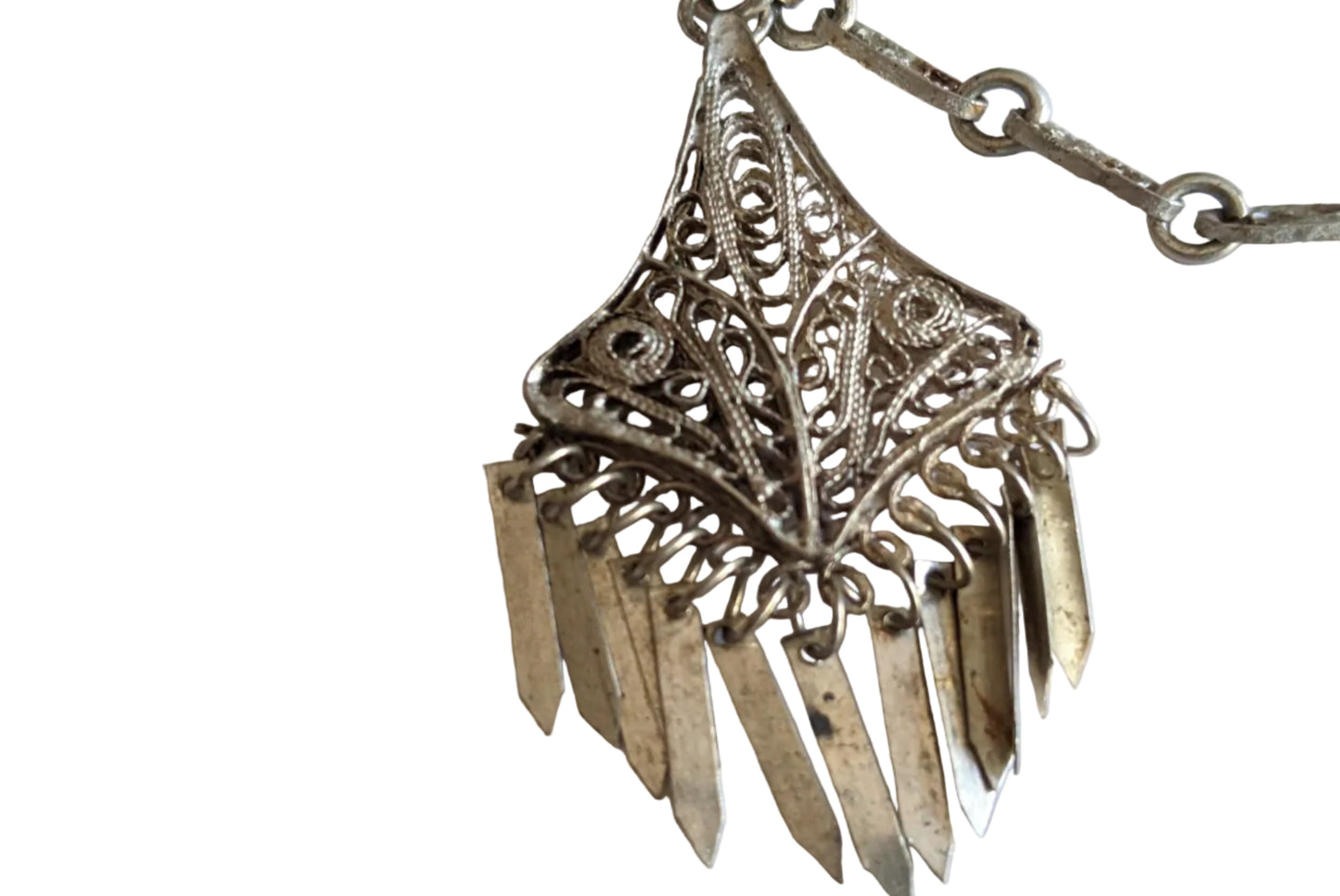 Silver filigree pendant with filigree chain on a white background