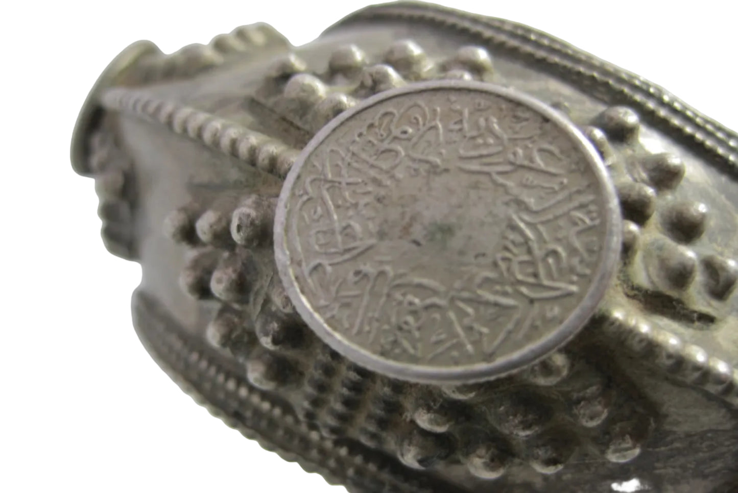 Silver bracelet with a coin inset on a white background