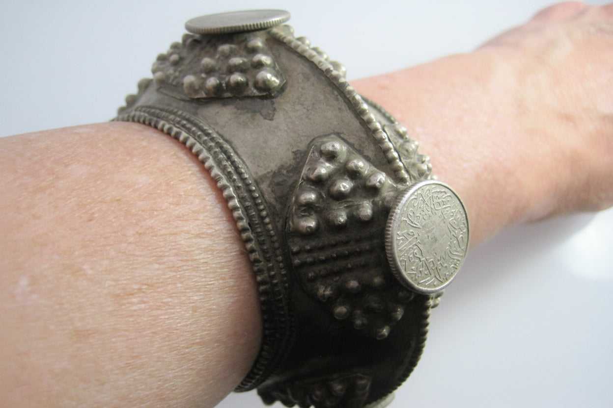Decorative metal bracelet on a wrist against a white background