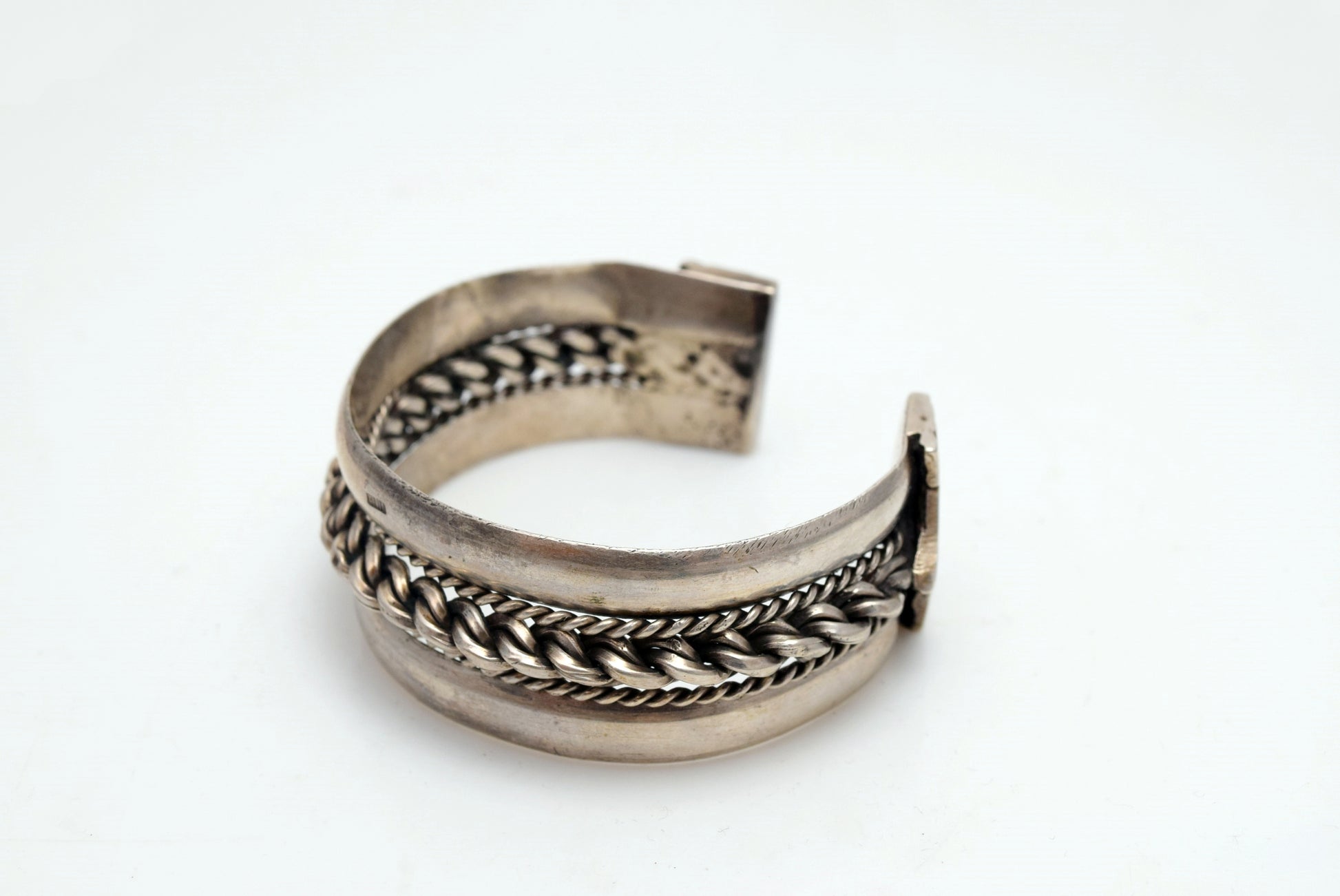 Silver bracelet with intricate designs on a white background