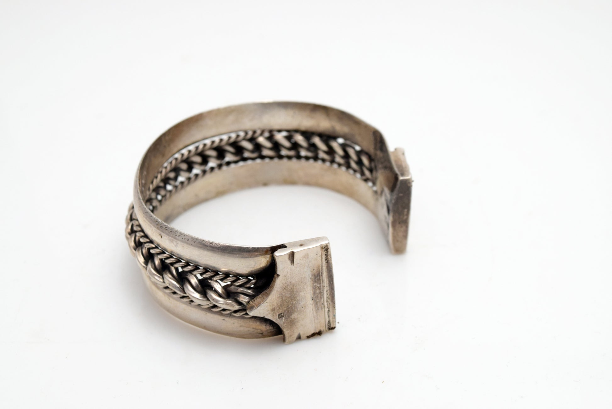 Silver bracelet with intricate designs on a white background