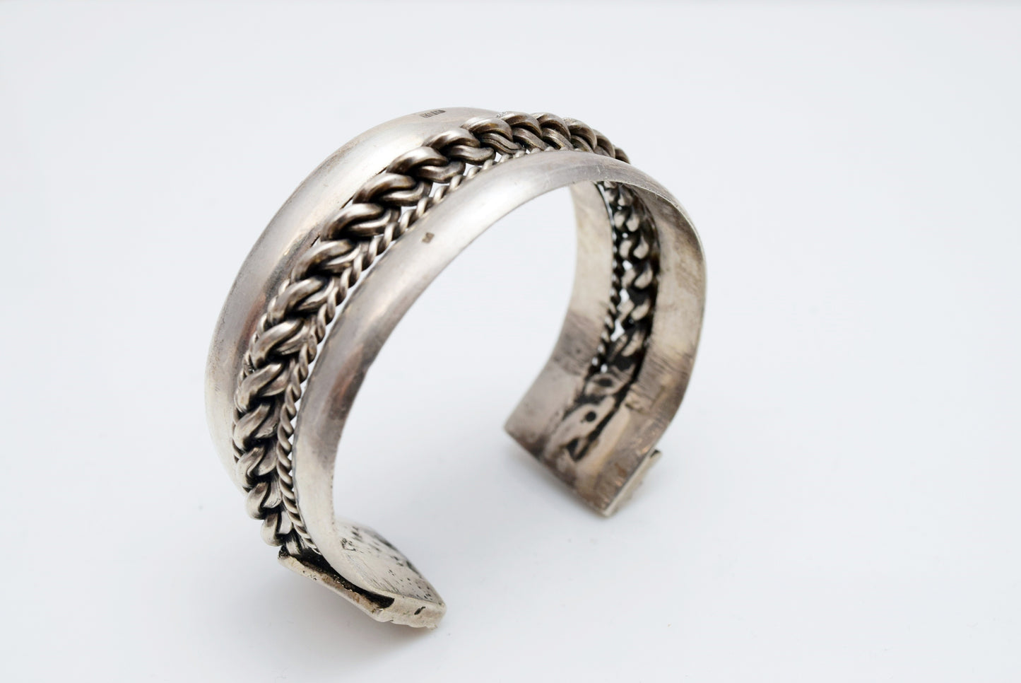 Silver bracelet with intricate designs on a white background