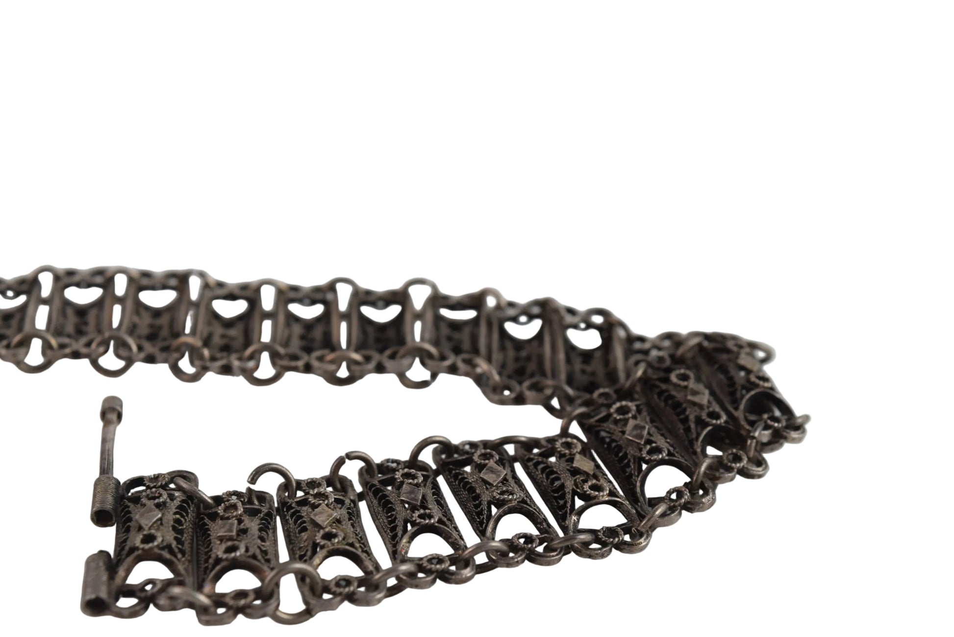 Silver bracelet with intricate designs on a white background