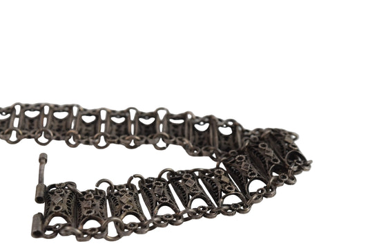 Silver bracelet with intricate designs on a white background