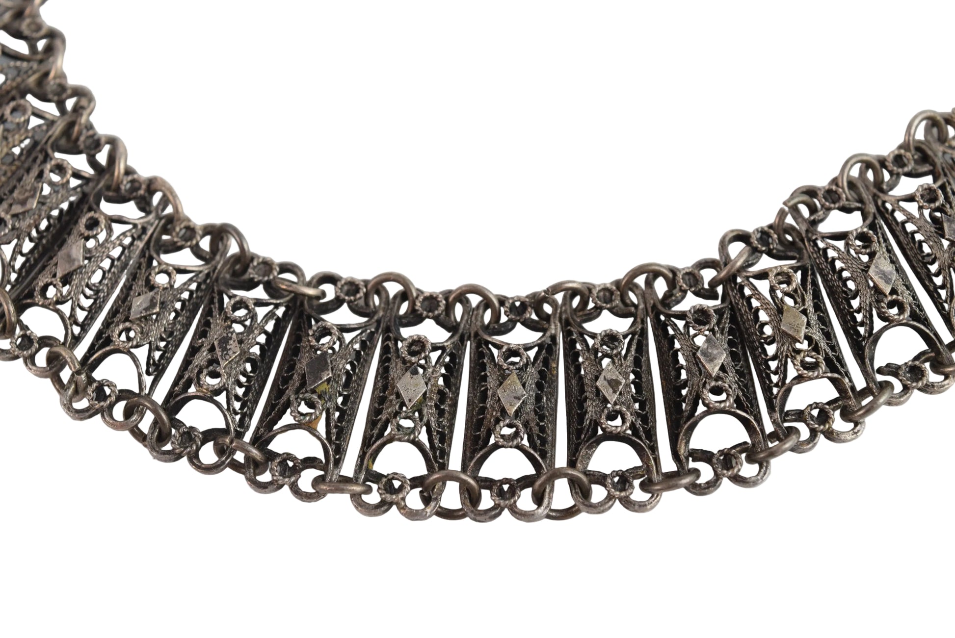 Silver filigree bracelet with intricate design on a white background