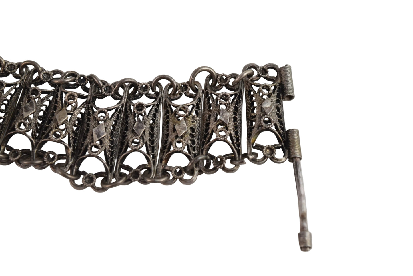 Silver bracelet with intricate design on a white background