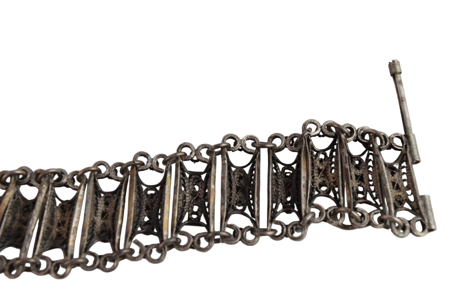Silver bracelet with intricate design on a white background