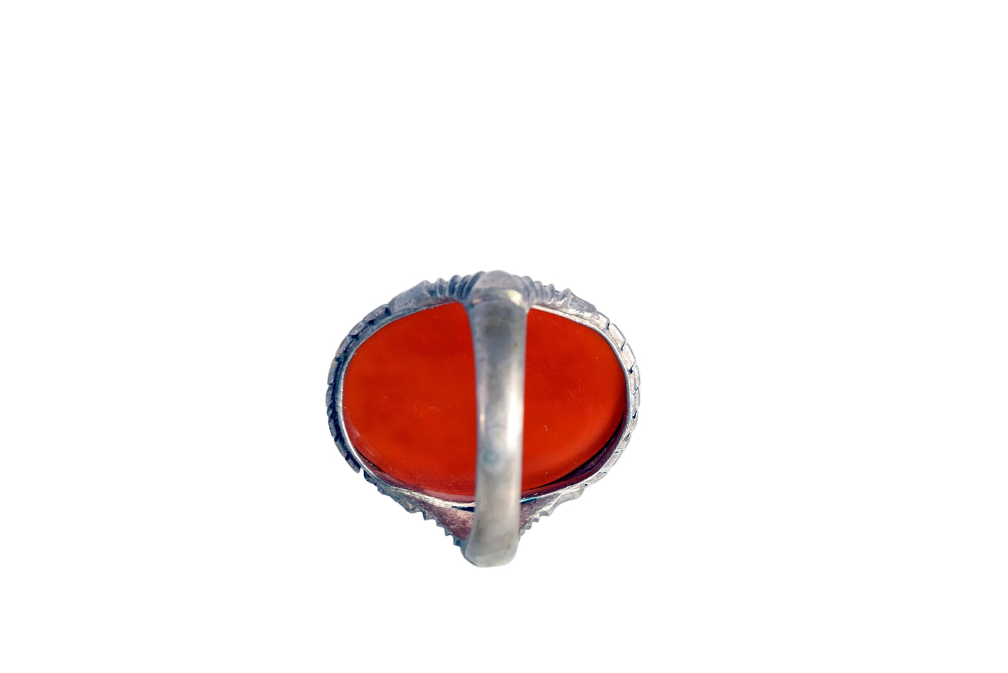 A silver ring featuring a large, oval-shaped red cabochon gemstone, photographed from directly above on a plain white background.