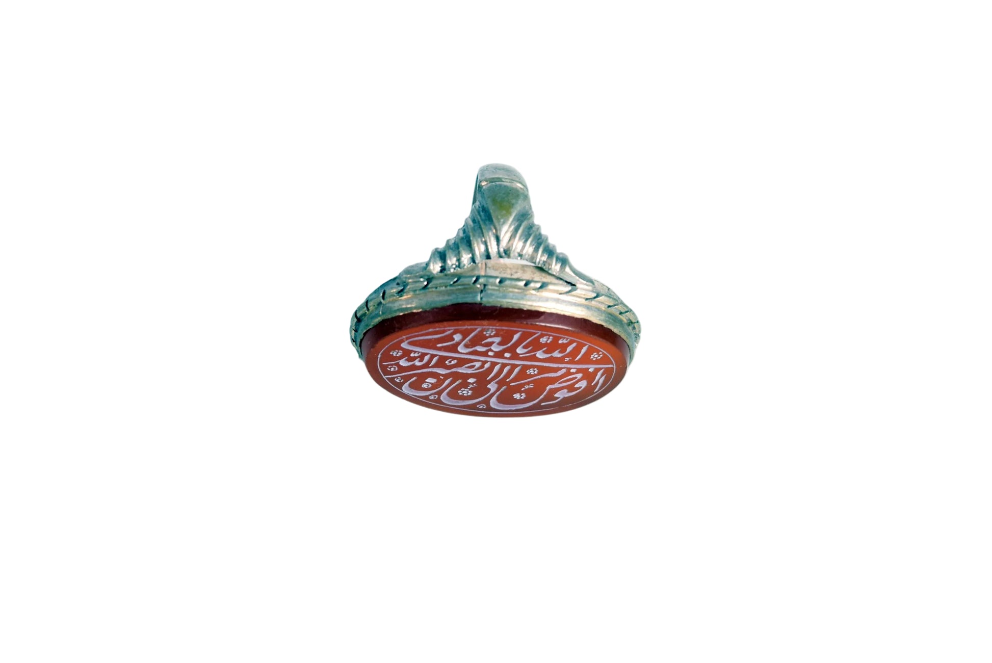 A silver ring with a red oval face featuring white Arabic calligraphy, photographed on a plain white background.