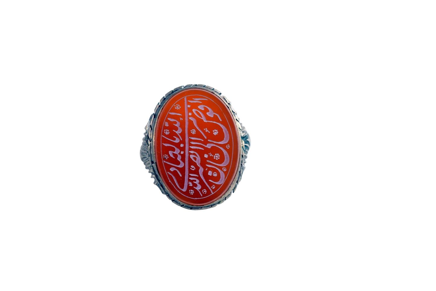 A silver ring featuring an oval red cabochon stone with white Arabic calligraphy, set against a plain white background.