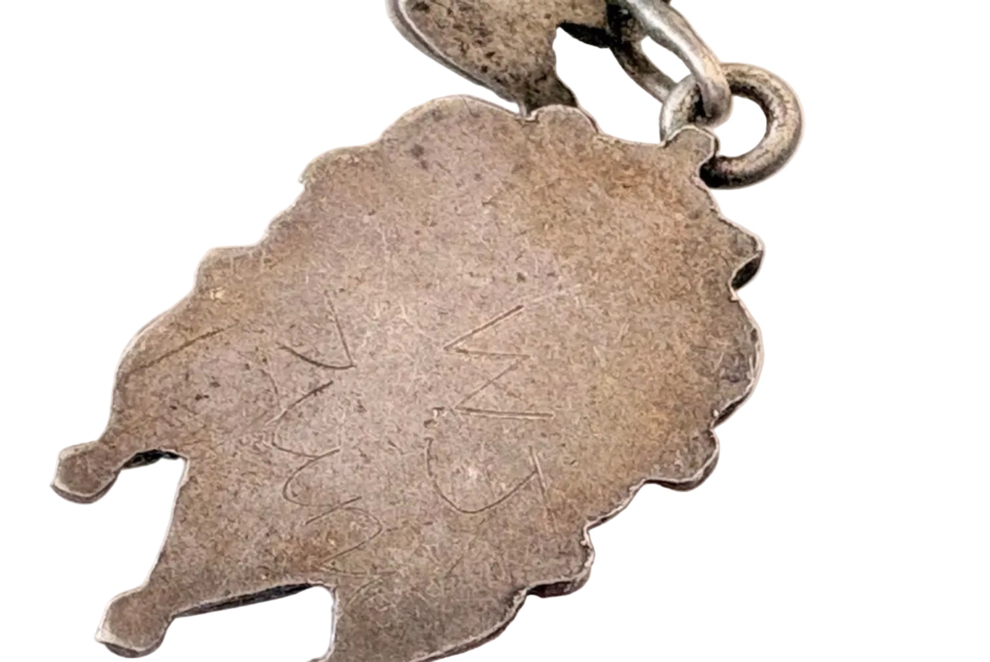 Close-up of a silver earrings with engraved signature WJ Zuni