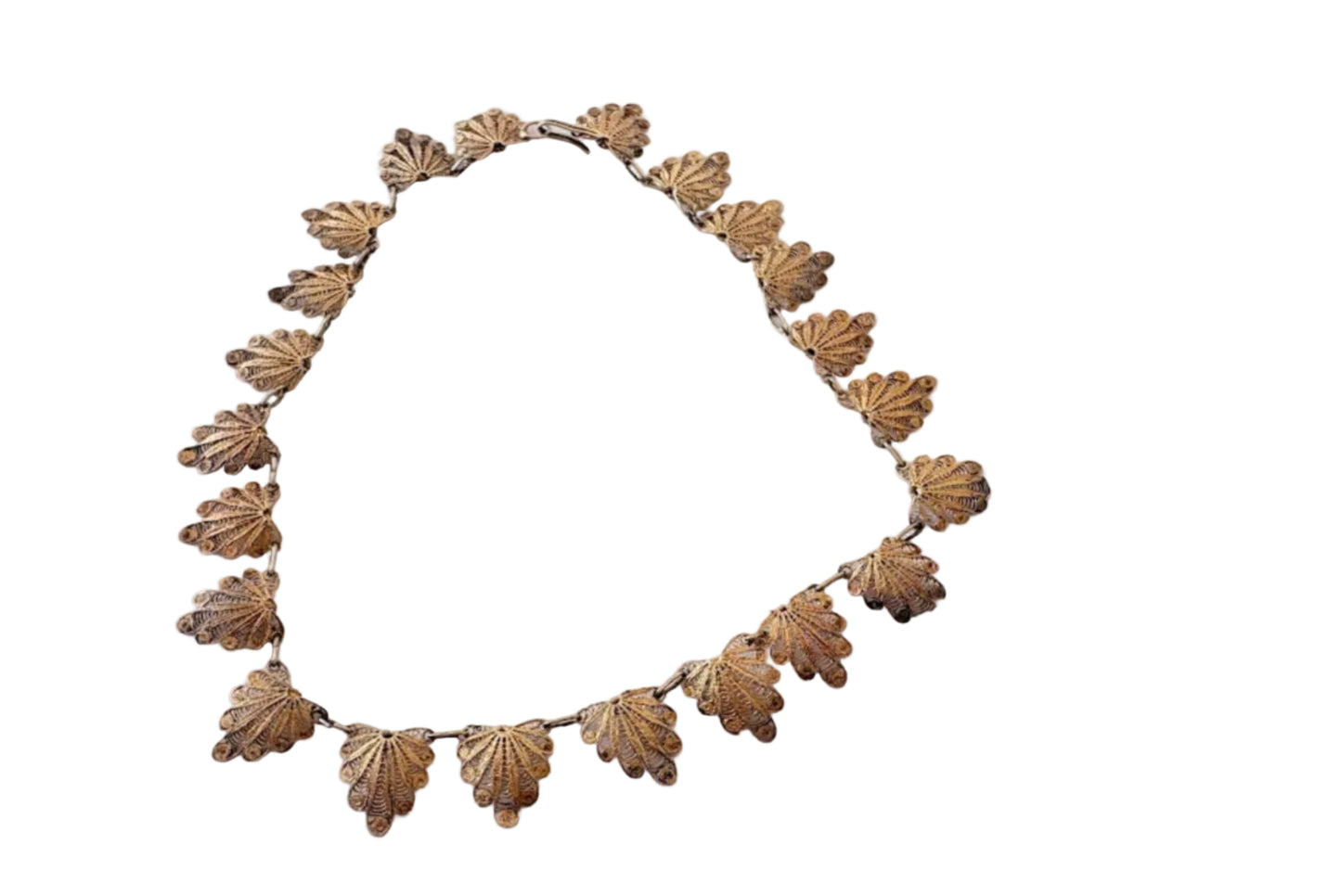 Back of necklace with shell-like patterns on a light gray background