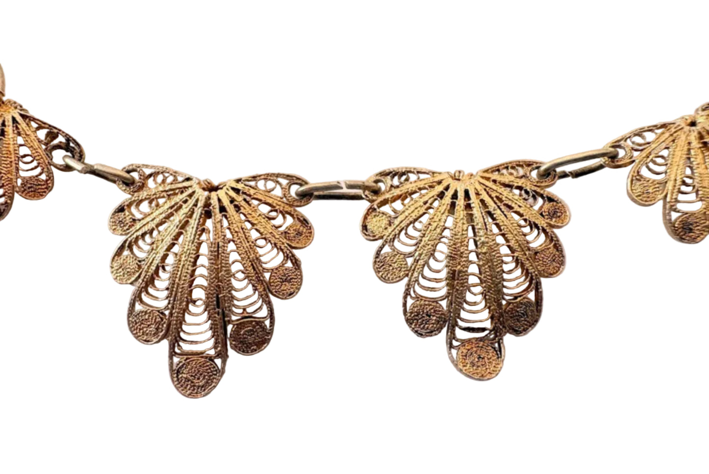 Close up of gold colored silver filigree choker on a light background
