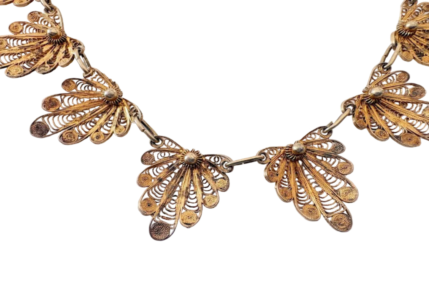 Gold filigree necklace on a light gray background