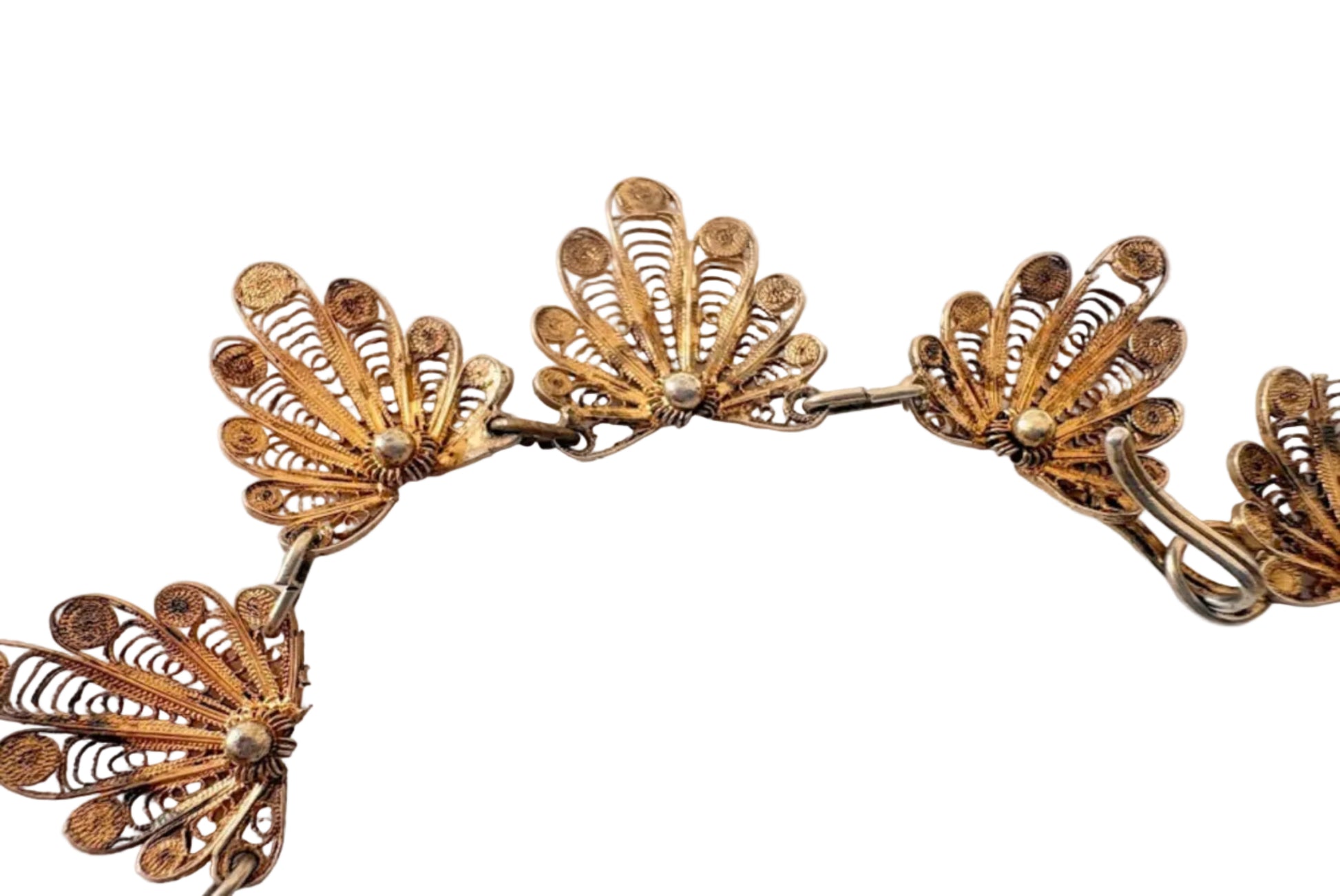 Gold necklace with intricate design on a light background