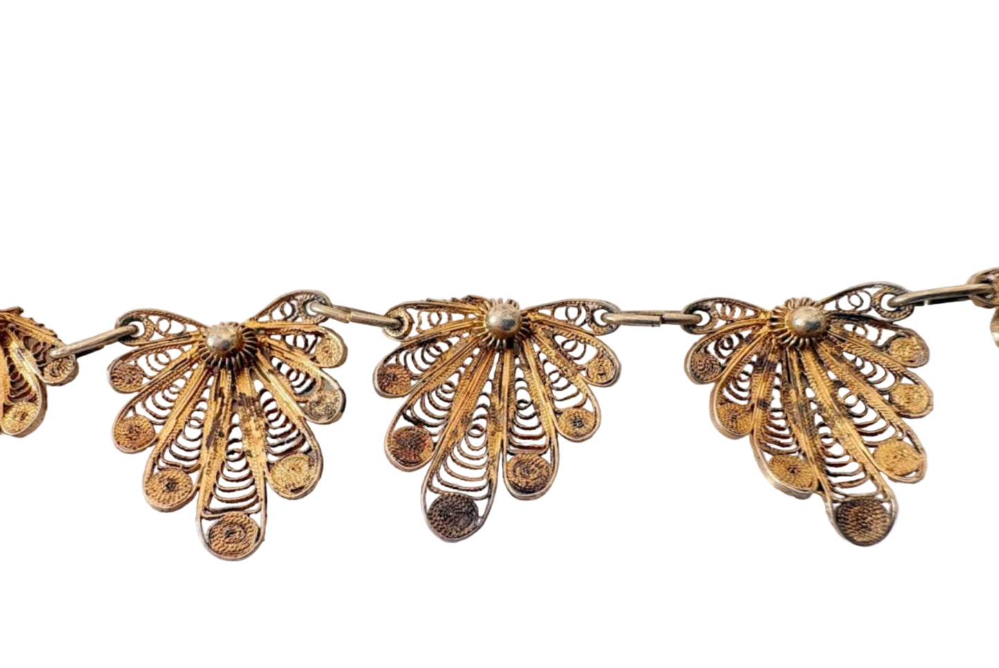 Gold filigree necklace on a light gray background
