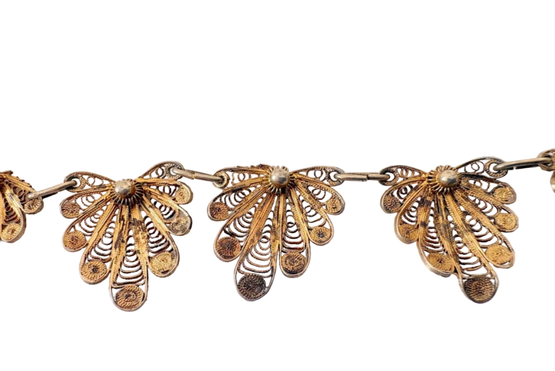 Gold filigree necklace on a light gray background