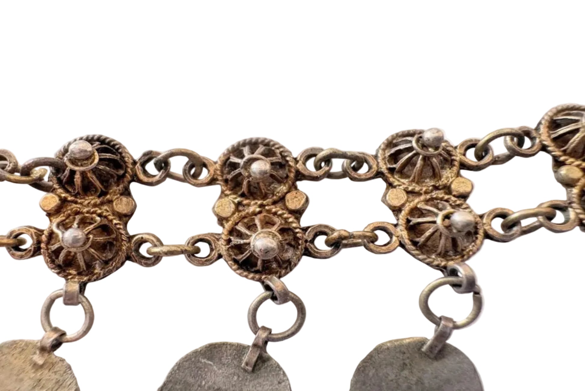 Decorative intricate designs and hanging pendants of a necklace on a white background