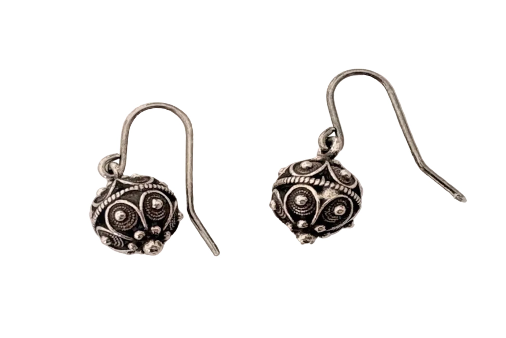 Pair of silver earrings with intricate designs on a white ackground