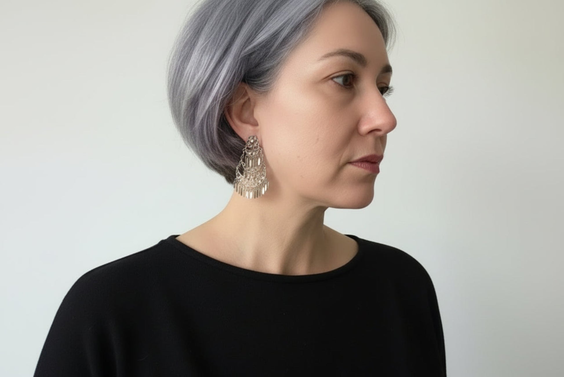 Person wearing a silver earring with a blurred background