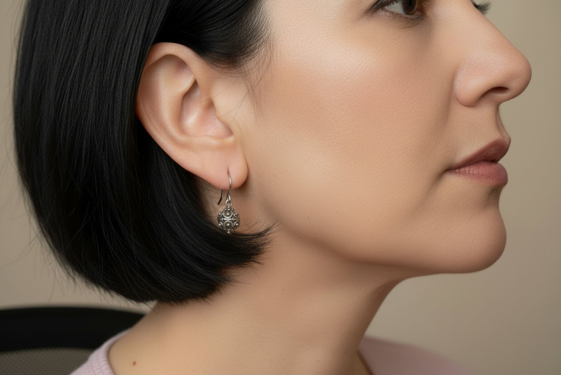 Close-up of an ear and a silver earring, blurred background