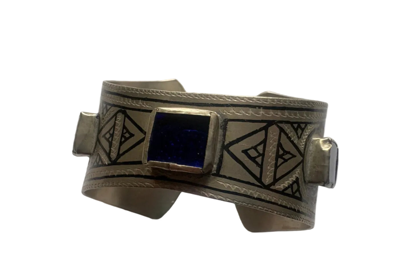 Silver bracelet with geometric designs and a blue stone on a white background