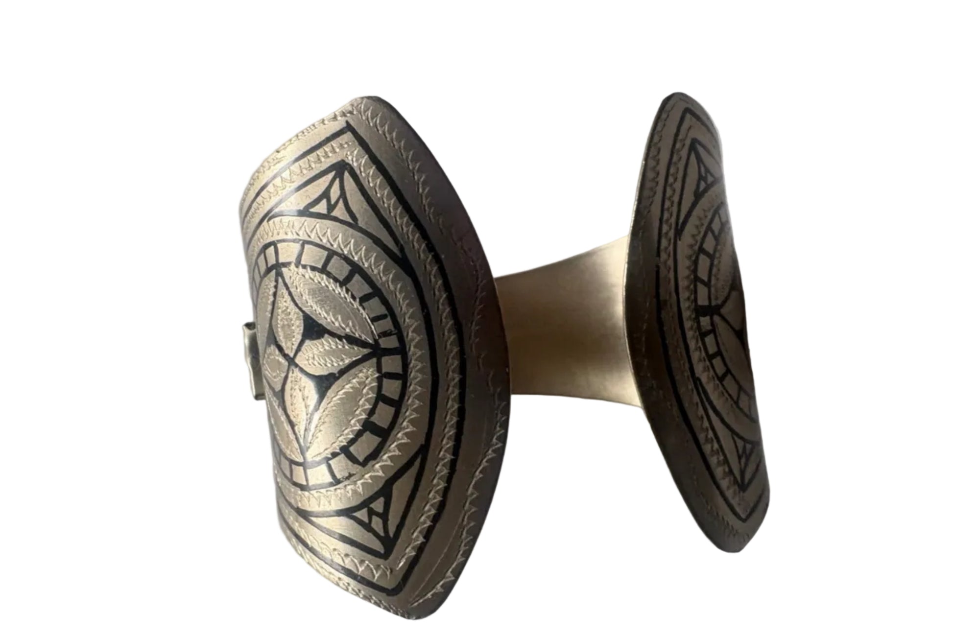The back of a flared bracelet with intricate designs on a white background