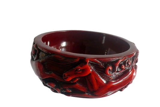 Decorative red and black bangle on a white background