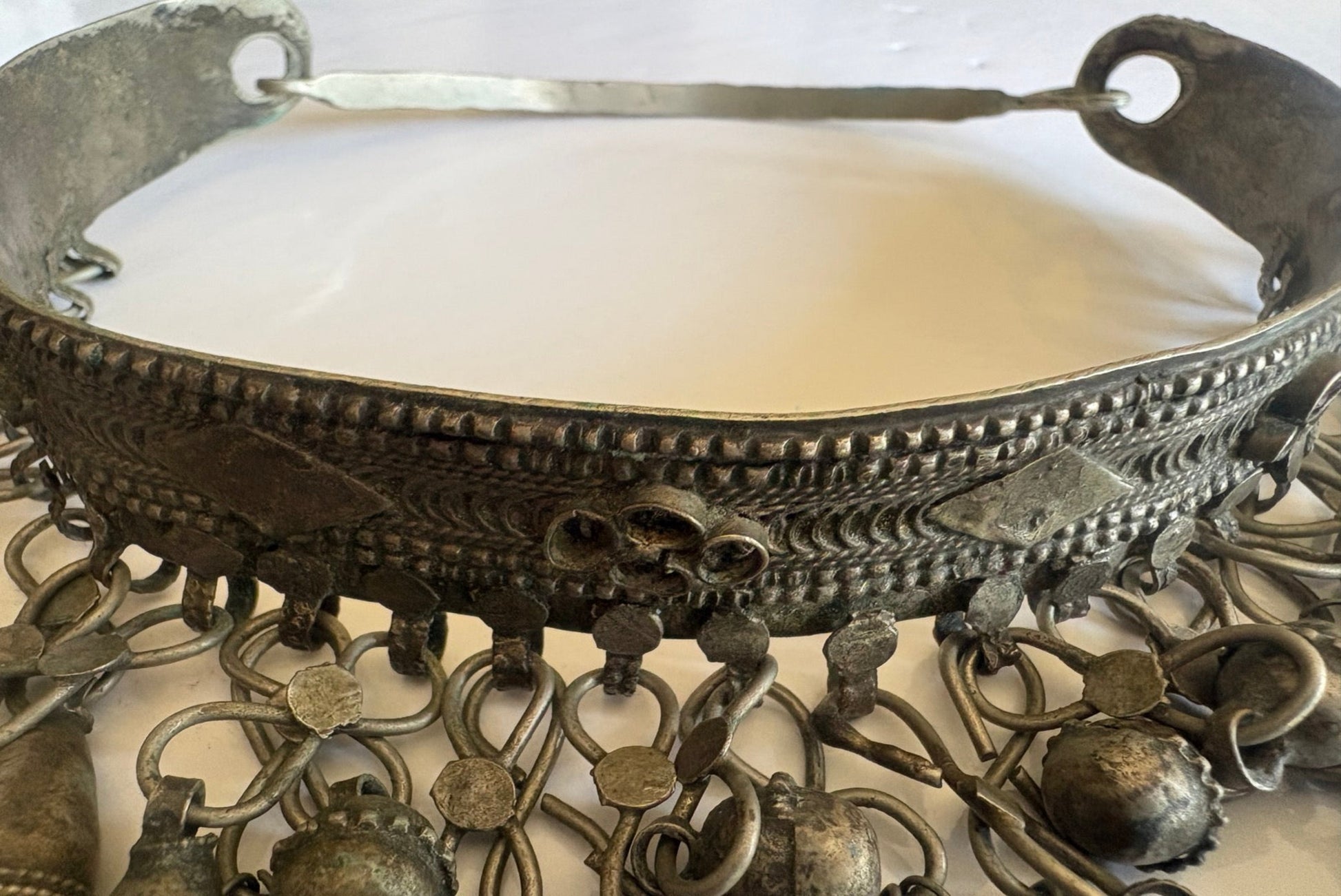 Decorative Saudi Torc necklace with intricate designs and hanging elements on a white background