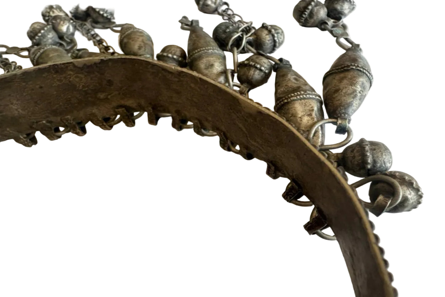 Close-up of a torc necklace with intricate designs on a white background