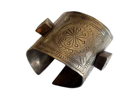 Silver bracelet with intricate designs on a white background