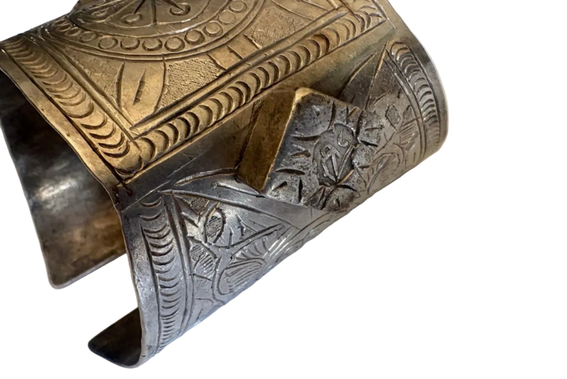 Decorative metal cuff with intricate patterns on a white background