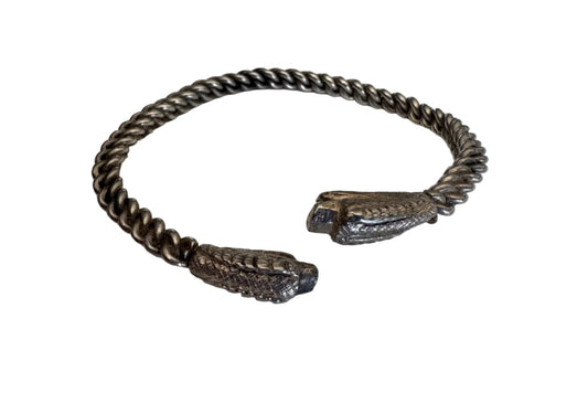 Silver chain bracelet with snake head designs on a white background