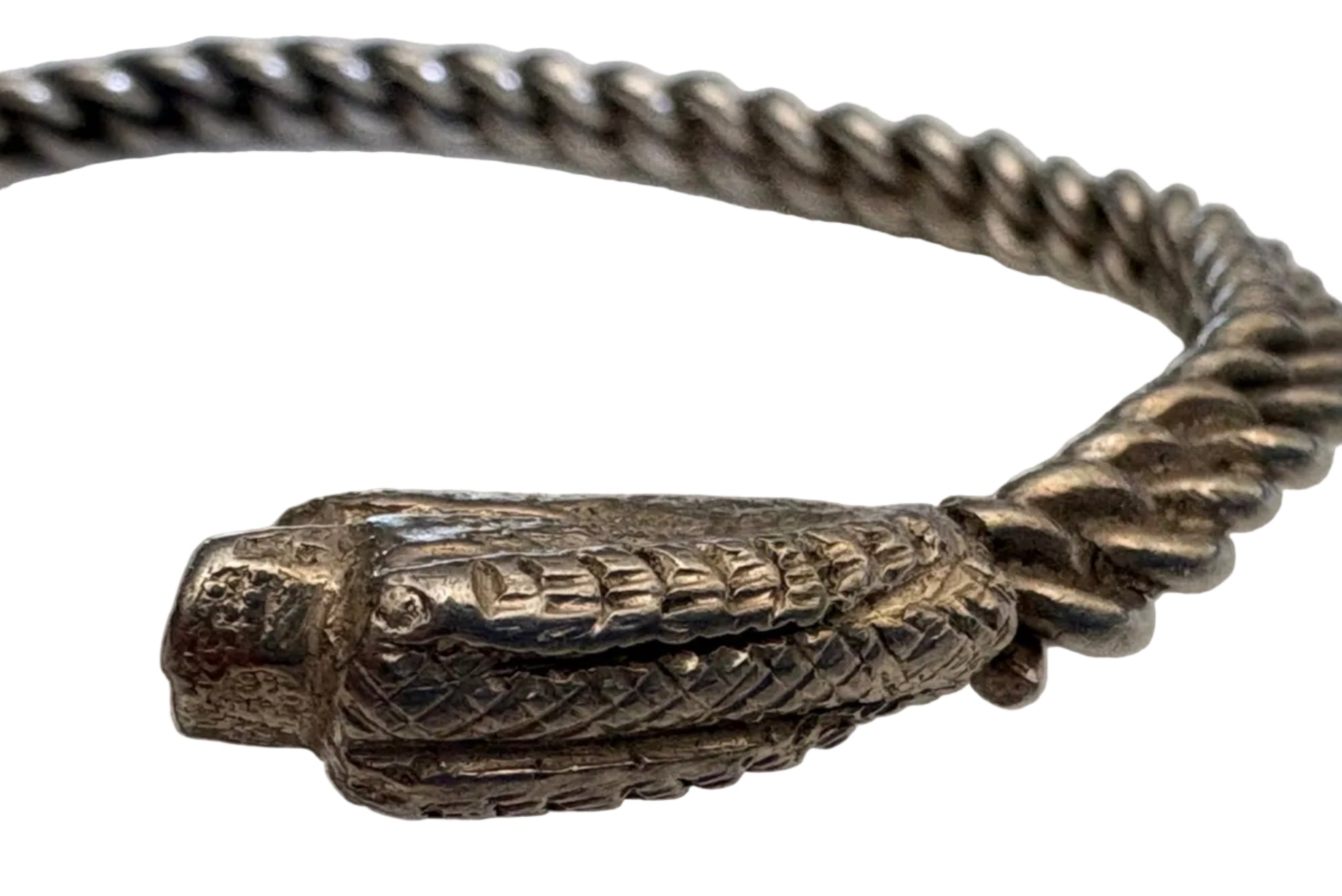 Silver bracelet with snake head design on a white background