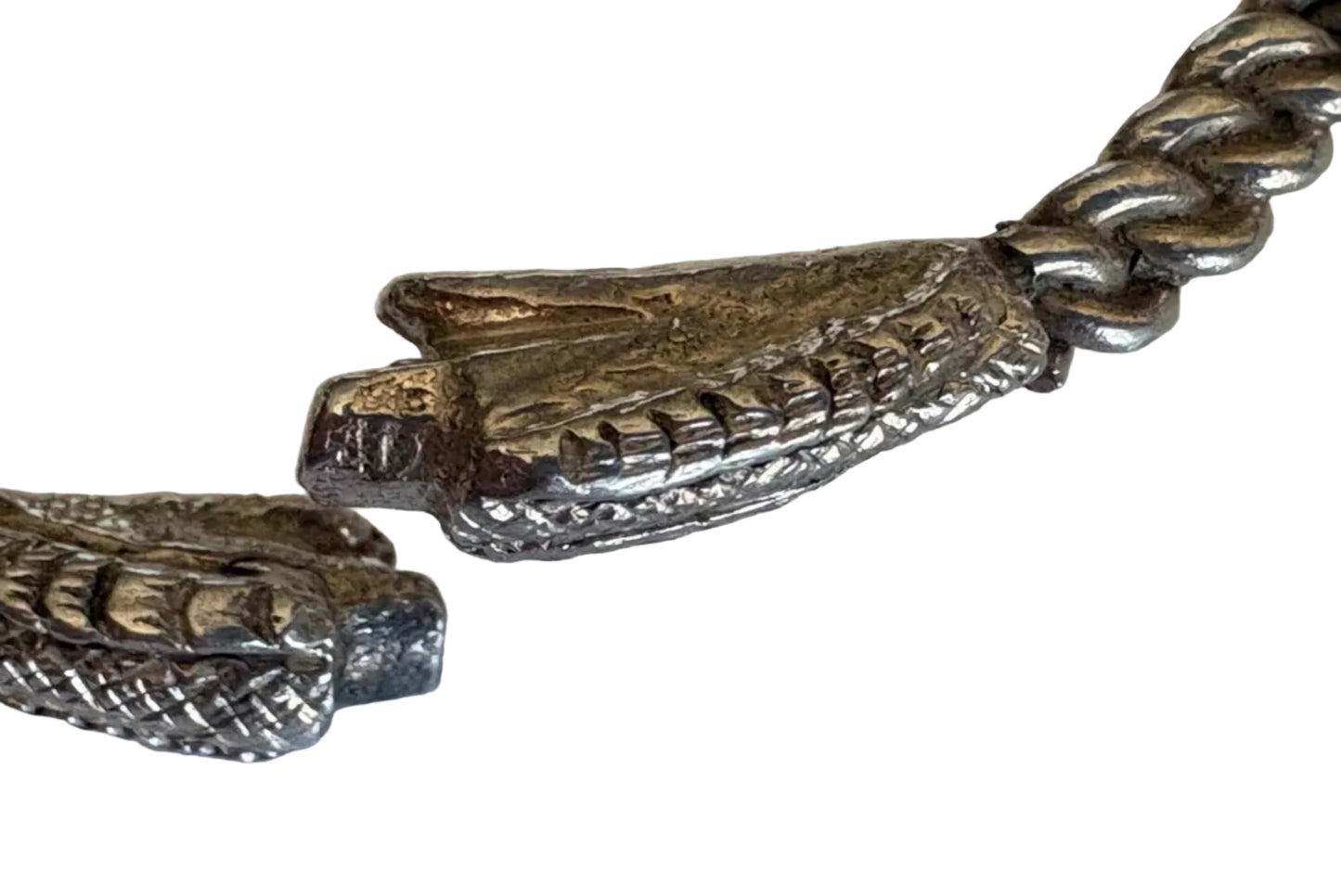Close-up of a silver snake bracelet on a white background