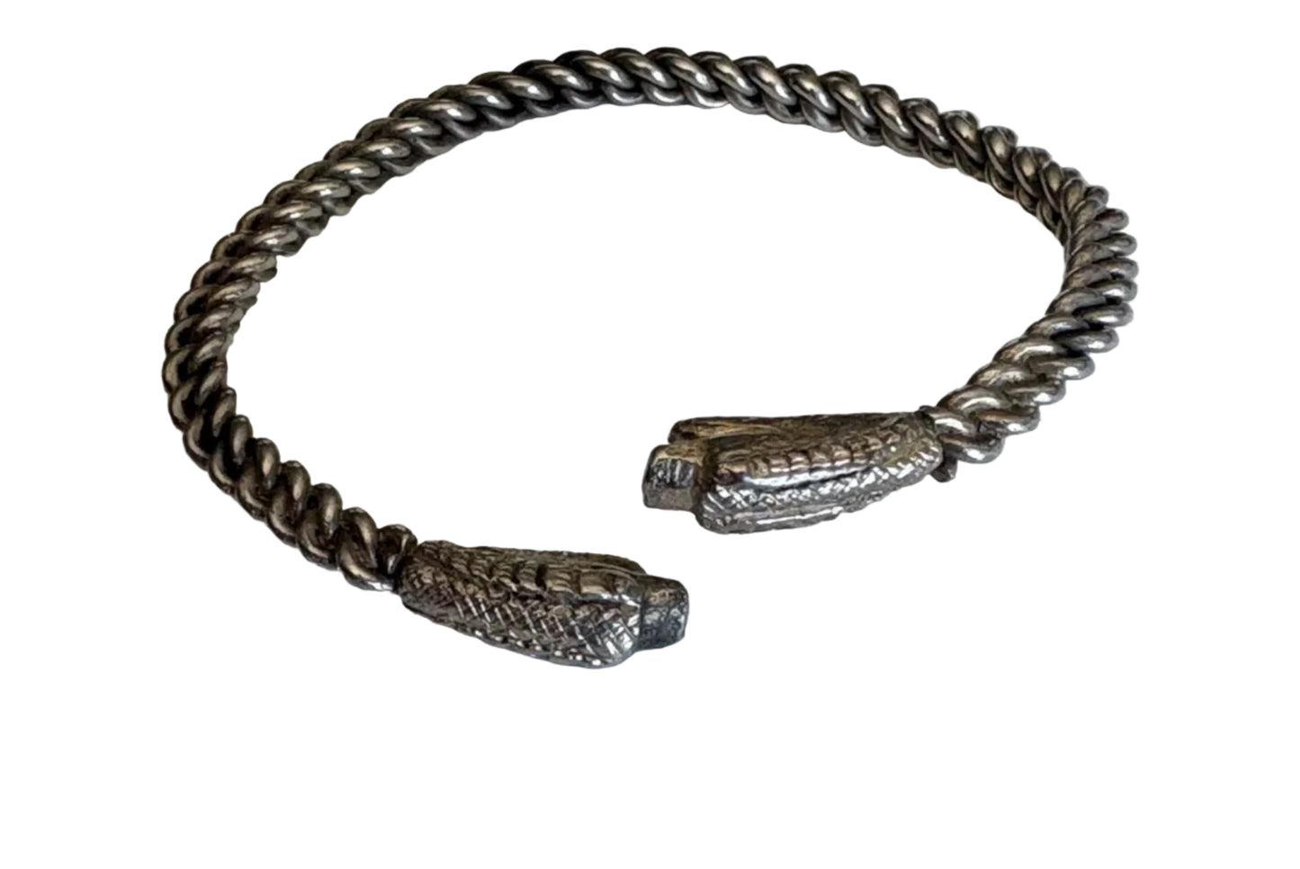 Silver bracelet with snake head designs on a light background