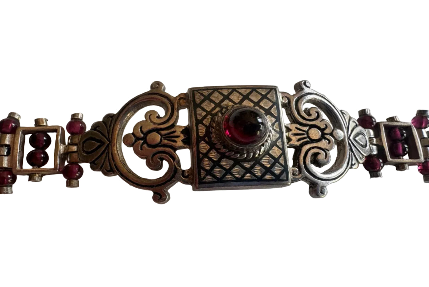 Decorative bracelet with red gemstones on a white background