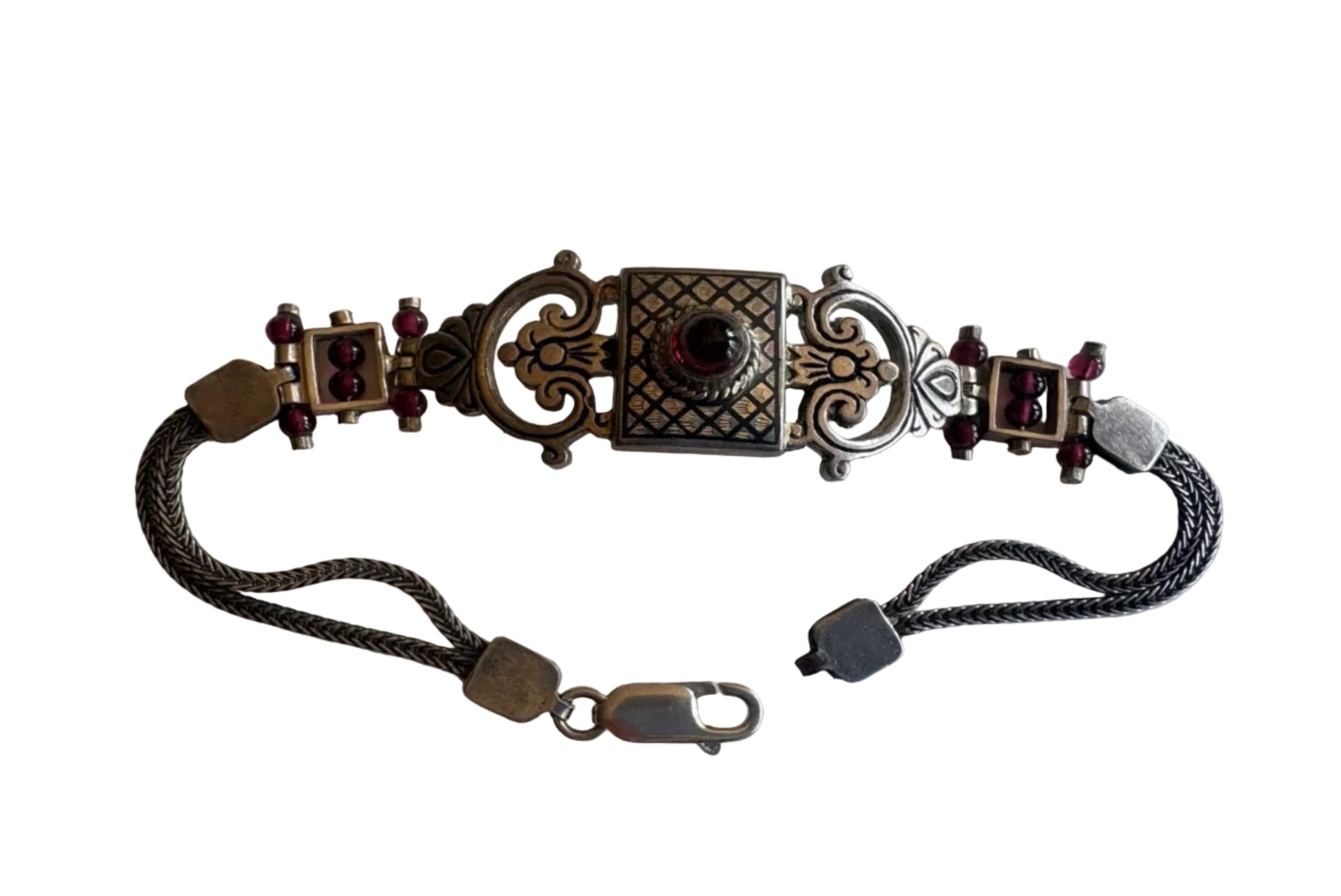 Decorative bracelet with intricate designs and gemstones on a white background
