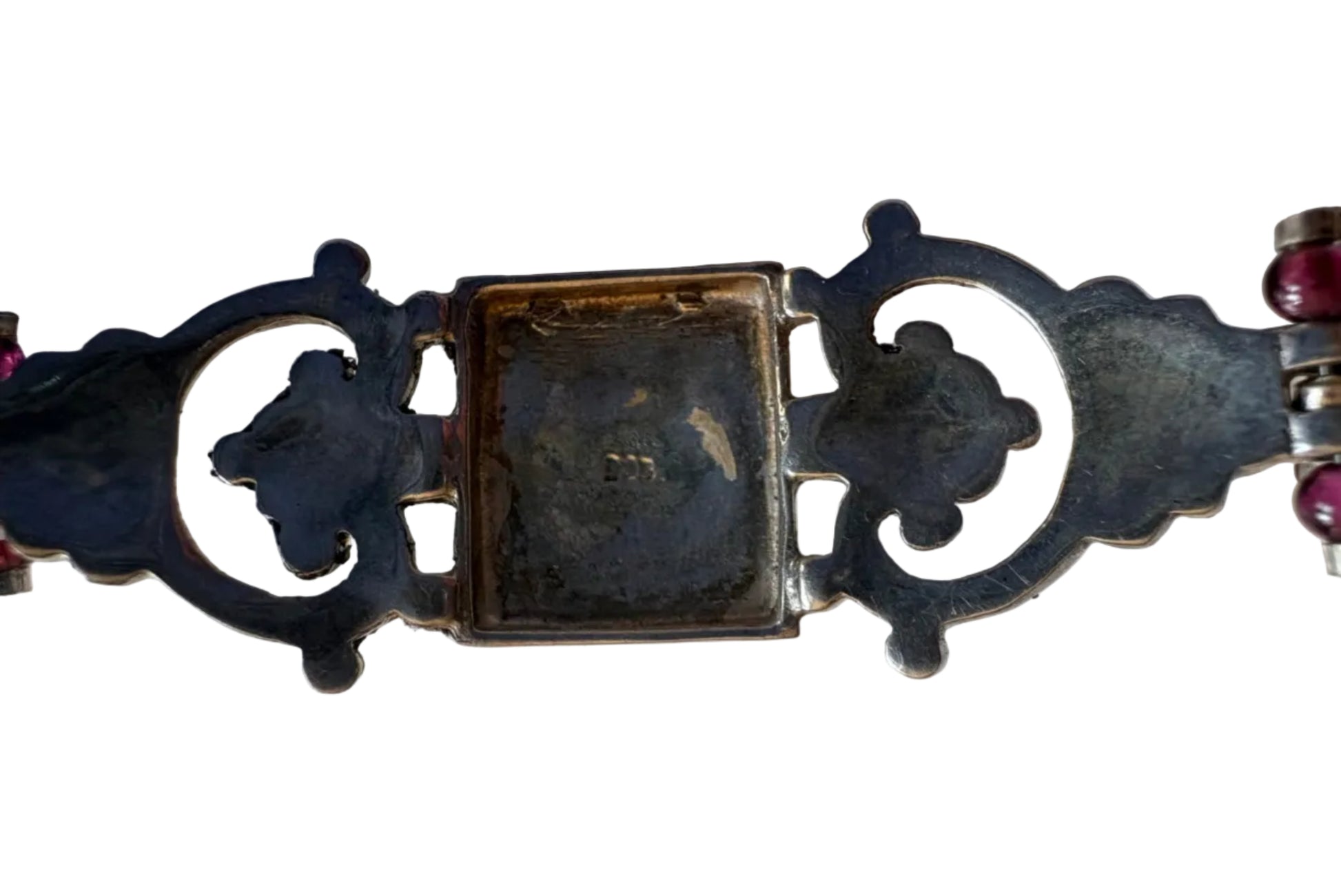 Detail of a decorative silver bracelet with intricate design on a light background