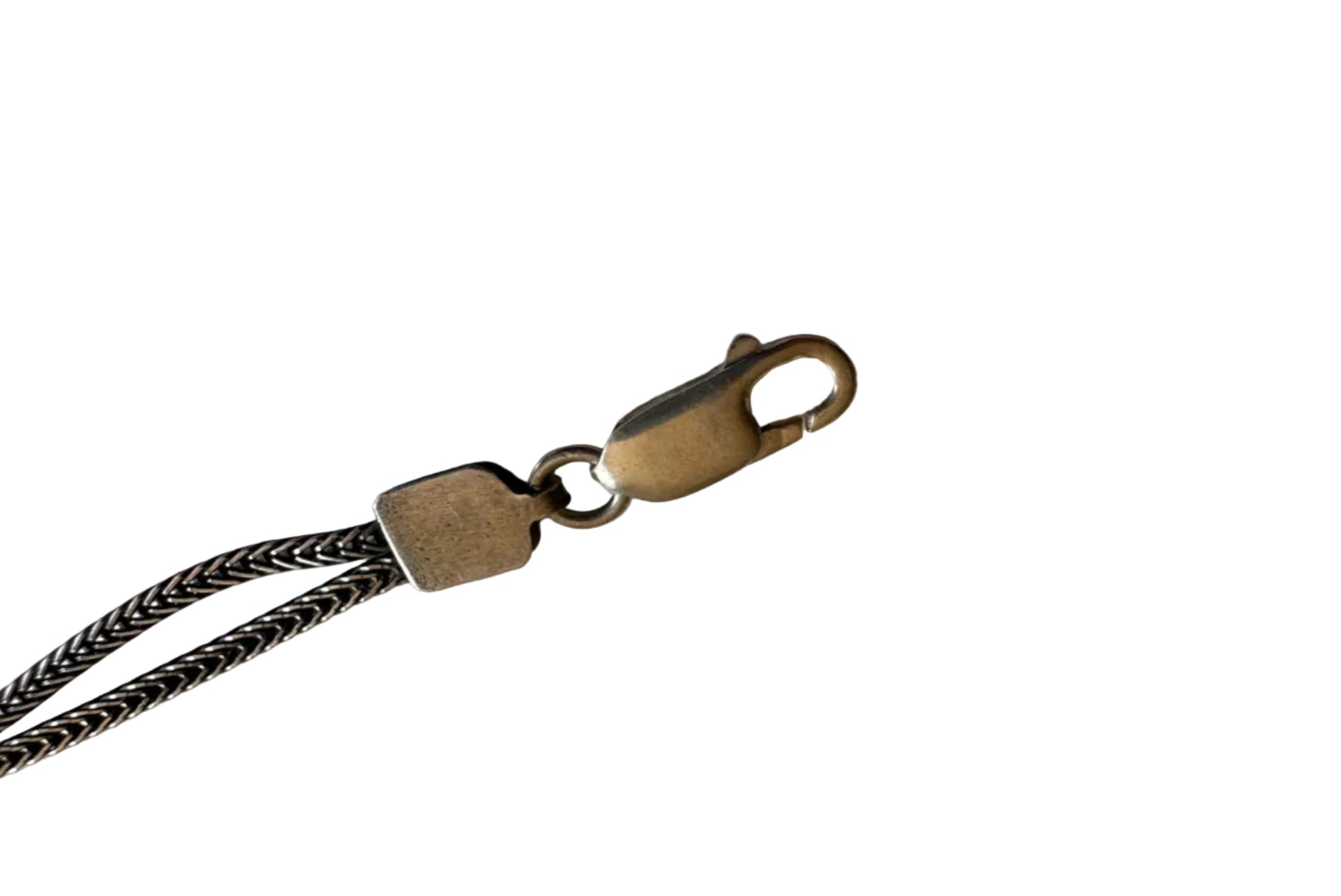 Silver clasp with braided chain on a light background