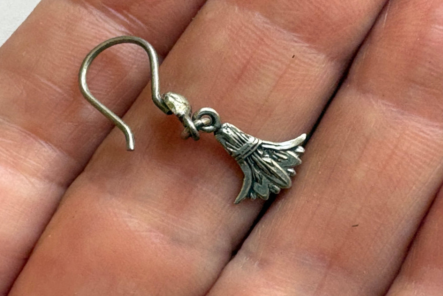 Silver lotus earring held on hand