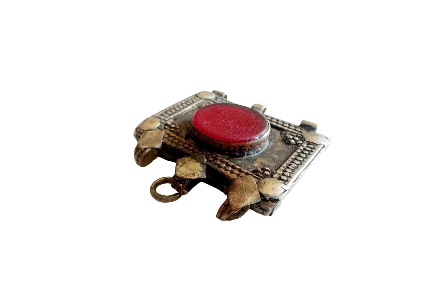 Decorative pendant with a red central gemstone on a white background