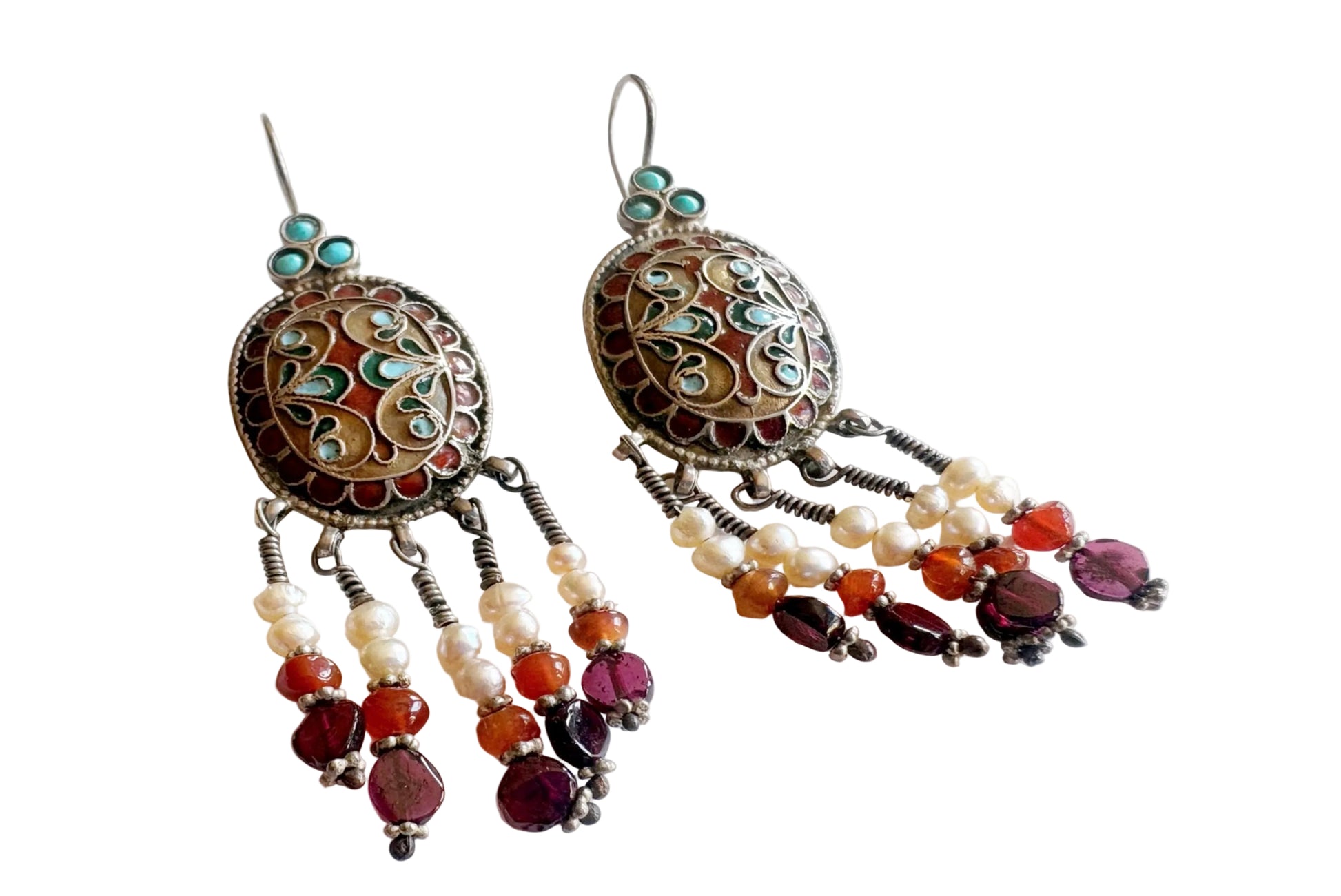Pair of ornate earrings with beads on a white background