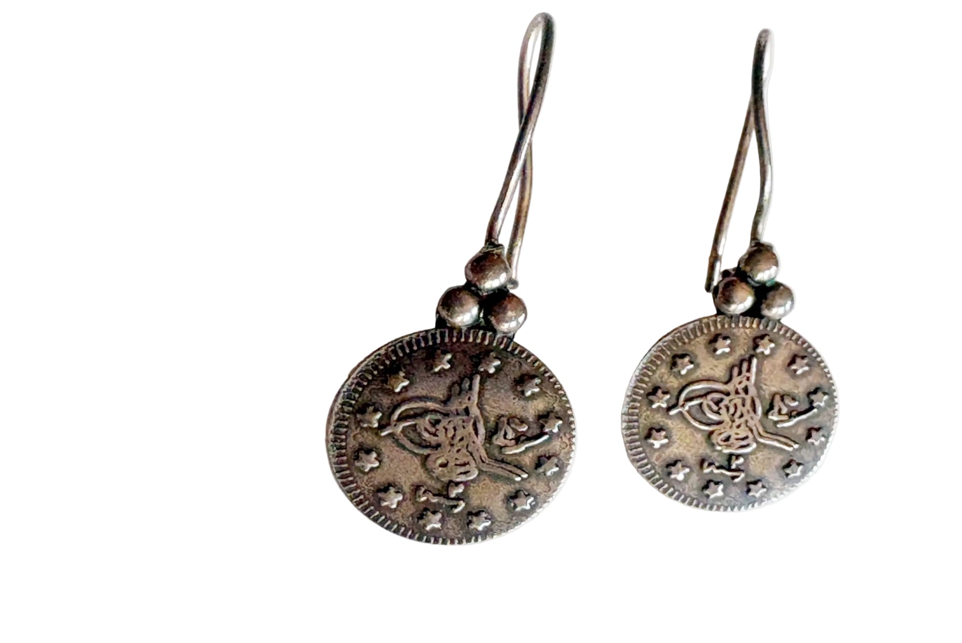 Pair of silver coin earrings on a white background