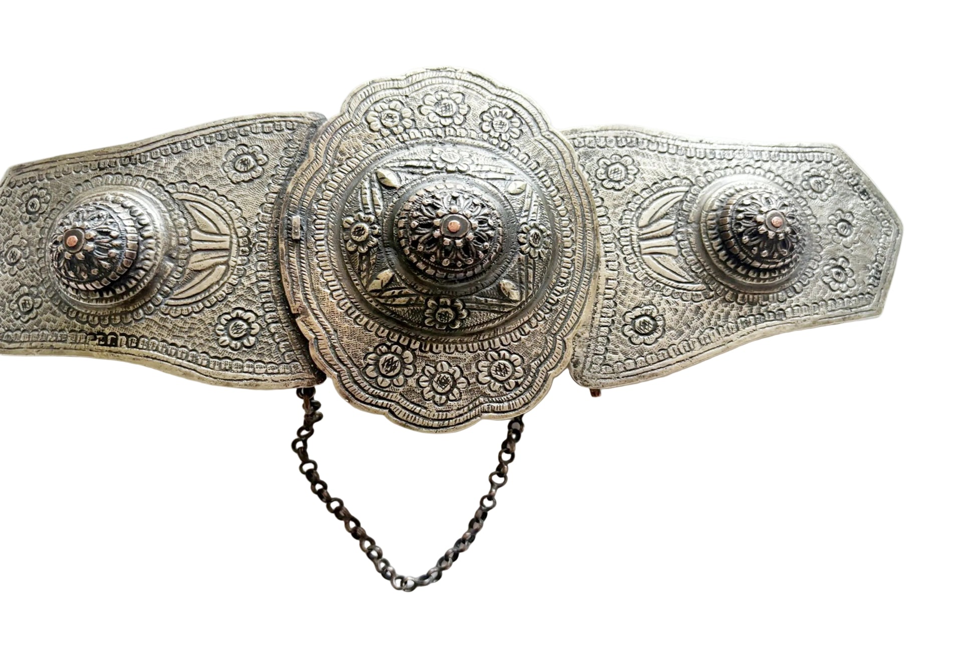 An ornate antique-style metal belt with intricate floral engravings, a large central medallion, and a short black chain hanging below, photographed on a plain white background.