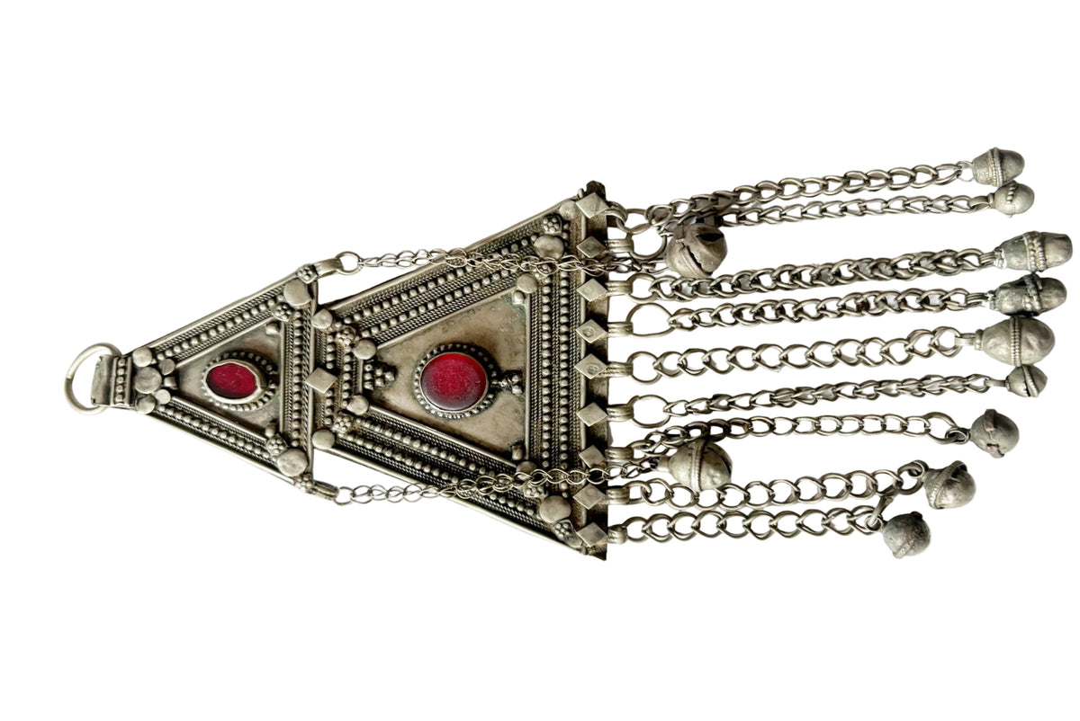 A silver-toned geometric pendant with red oval stones and multiple dangling chains, photographed on a plain white background.