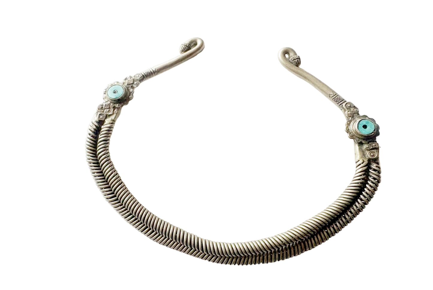 An antique-style silver-toned metal torc necklace with intricate woven detailing and small turquoise stone accents on both ends, displayed on a clean white background.