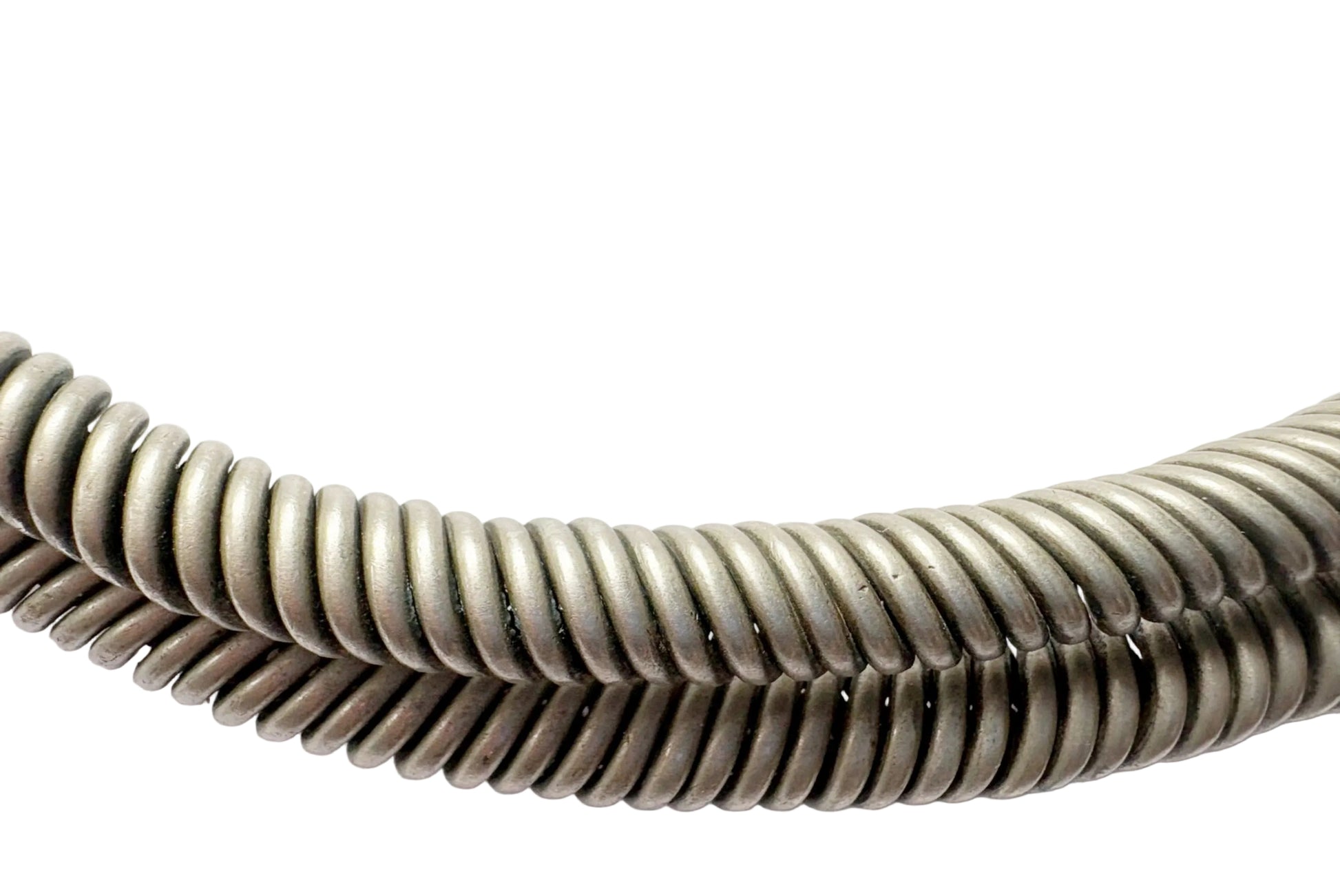 A close-up of a coiled wire on a torc necklace curved against a plain white background.